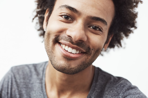 Feche o retrato do homem africano alegre bonito sorrindo.