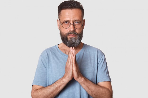 Feche o retrato do homem barbudo bonito vestindo óculos e camiseta casual cinza