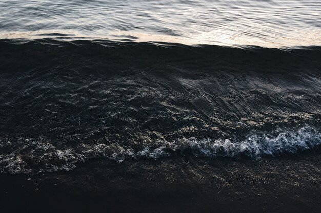 Feche o tiro das ondas do mar atingindo a costa