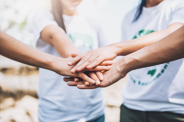 Feche o trabalho em equipe voluntário de pessoas colocando o dedo nas mãos em forma de estrela juntospilha de mãosunidade e trabalho em equipe no dia mundial do meio ambiente