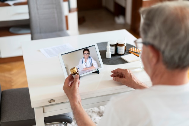 Foto grátis feche o velho conversando com um médico online