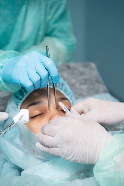 Feche os médicos realizando rinoplastia