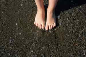 Foto grátis feche os pés das crianças na praia