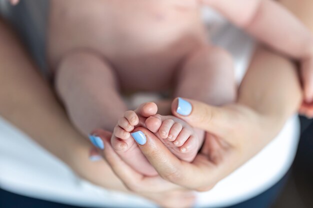 Foto grátis feche os pés de um recém-nascido nas mãos da mãe