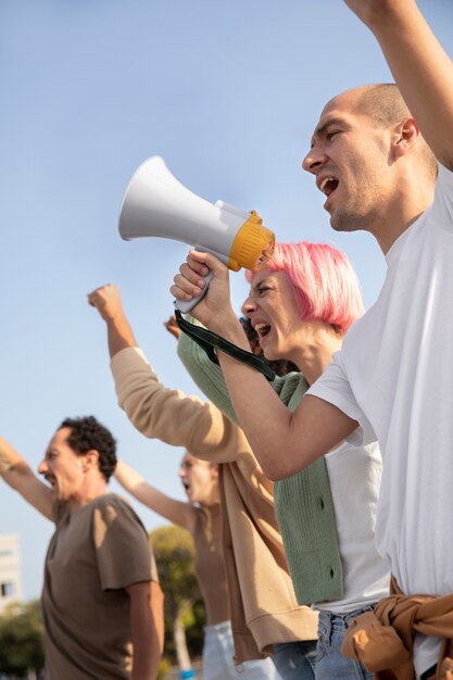 Feche pessoas protestando com megafones