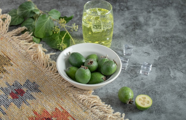 Feijoa fresca e copo de limonada na mesa de mármore