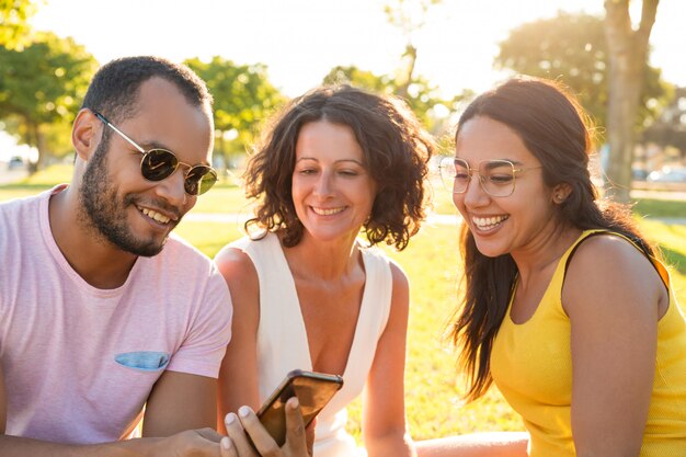 Feliz alegre bonitão mostrando o conteúdo no telefone