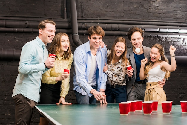 Feliz, amigos, olhar, bola, enquanto, homem, jogando cerveja, pong, ligado, tabela