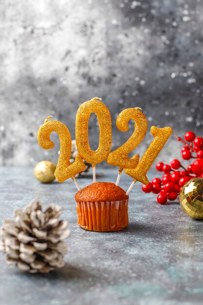 Feliz Ano Novo de 2021, cupcakes com velas douradas.