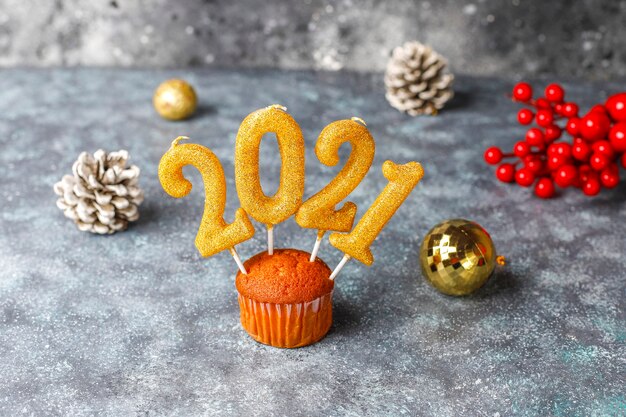 Feliz Ano Novo de 2021, cupcakes com velas douradas.