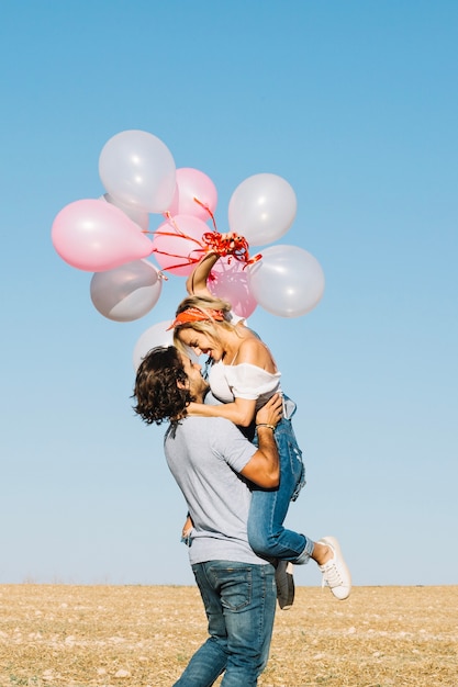 Feliz casal com balões se divertindo