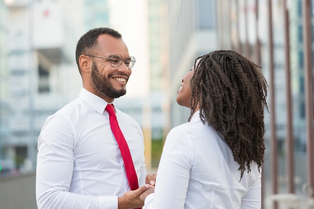 Feliz casal diversificado conversando lá fora