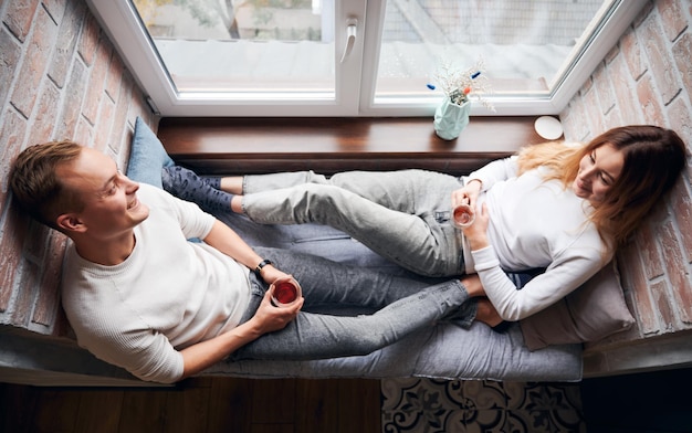 Feliz casal jovem bebendo chá em casa