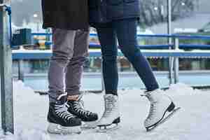 Foto grátis feliz casal jovem namorando na pista de gelo, abraçando e aproveitando o inverno