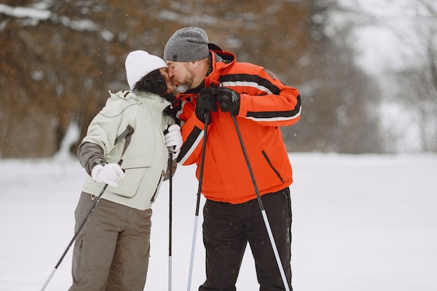 Feliz casal maduro em winter park. Pessoas com roupas esportivas caminhando na floresta em lazer