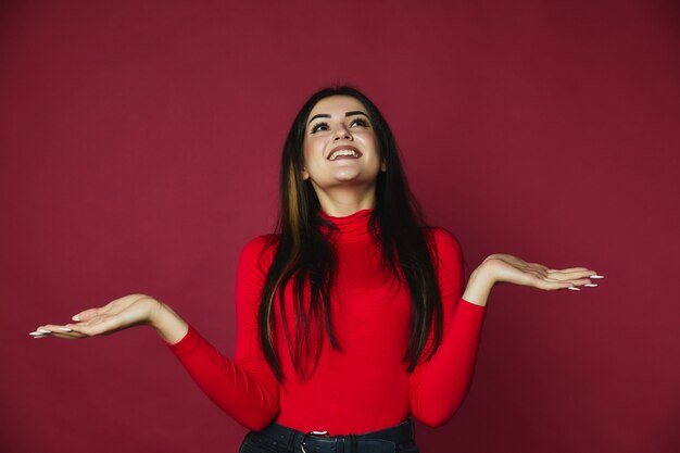 feliz caucasiana morena linda garota vestida de camisola vermelha está olhando para o topo