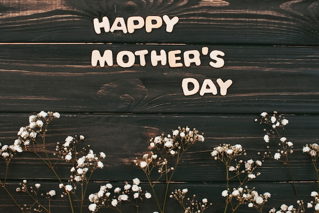 Foto grátis feliz dia das mães inscrição com ramos de flores