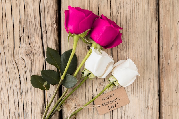 Feliz dia das mães inscrição com rosas na mesa de madeira