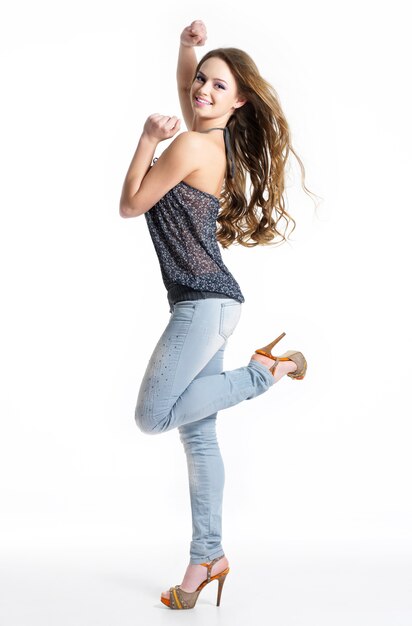 Feliz e alegria linda garota em jeans elegantes da moda - isolado no branco. Modelo posando em estúdio