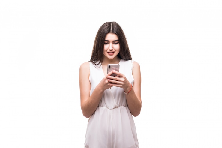 Foto grátis feliz e linda jovem modelo em um vestido branco moderno com telefone