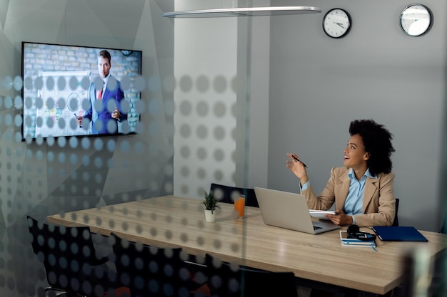 Foto grátis feliz empresária blck falando enquanto tem uma reunião online com o gerente corporativo do escritório