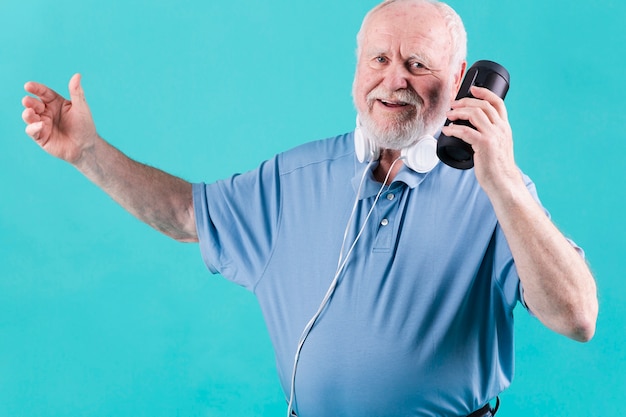 Foto grátis feliz escuta música sênior no alto-falante