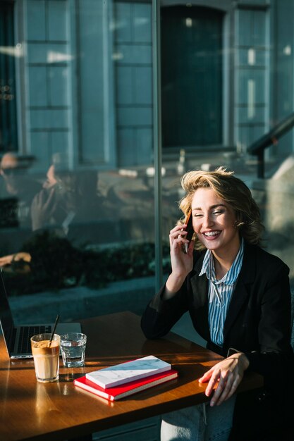 Feliz, executiva, sentando, em, restaurante, usando, telefone móvel