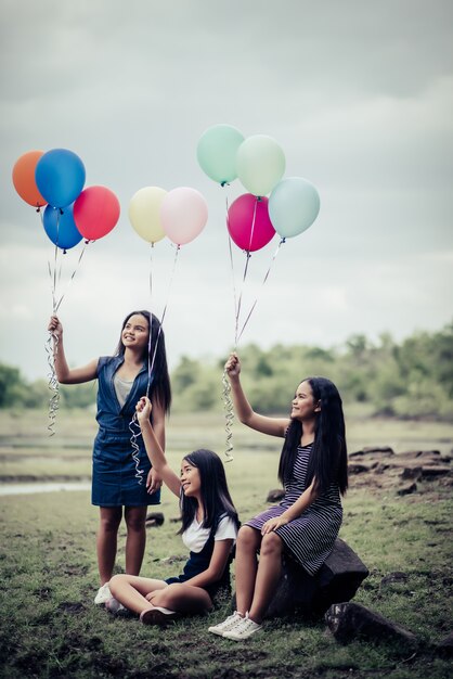 Feliz, grupo, amigos menina, mão, segurando, balões coloridos