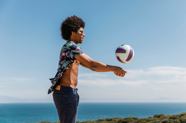 Feliz, homem americano africano, jogar bola, contra, céu azul