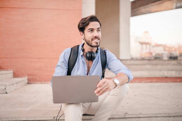 Feliz, homem jovem, usando computador portátil