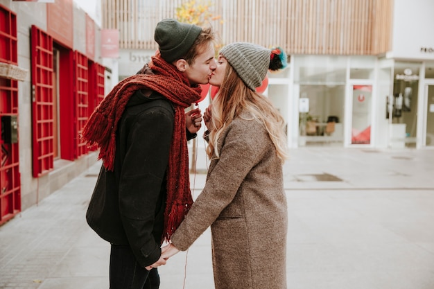 Feliz jovem casal se beijando na rua