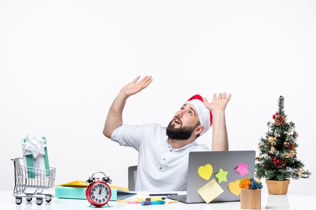 Feliz jovem empresário positivo com chapéu de papai noel trabalhando