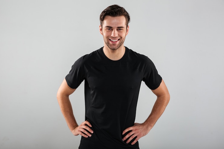 Foto grátis feliz jovem esportes homem posando isolado sobre parede cinza