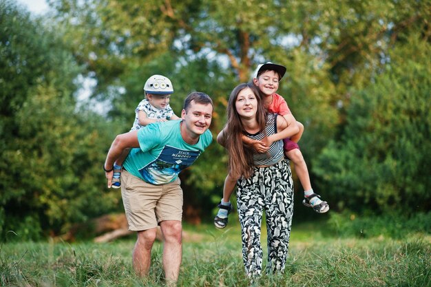 Feliz jovem mãe mãe pai dois filhos filho na natureza se divertindo