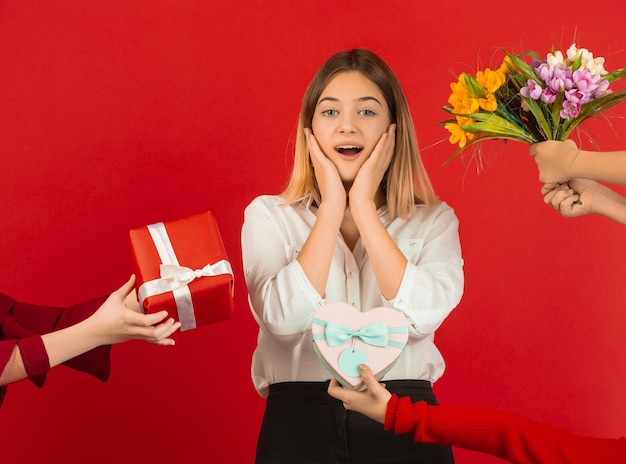 Foto grátis feliz, linda garota caucasiana isolada no estúdio vermelho