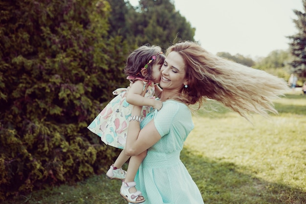 Feliz mãe e filha rindo juntos ao ar livre