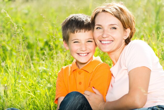 Foto grátis feliz mãe e filho no retrato ao ar livre do prado primavera