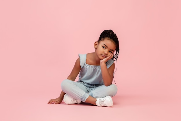 Feliz menina morena de cabelos compridos isolada no fundo rosa do estúdio Parece feliz alegre sincero Copyspace Conceito de emoções de educação infantil