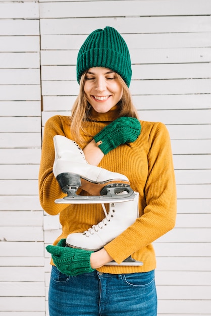 Feliz, mulher, em, suéter, segurando, patins