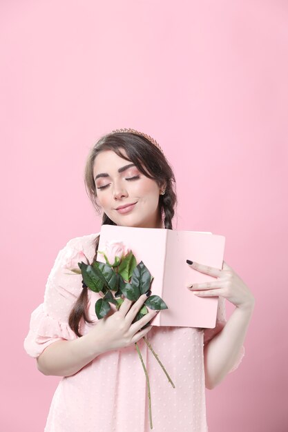Feliz mulher segurando rosas e livro