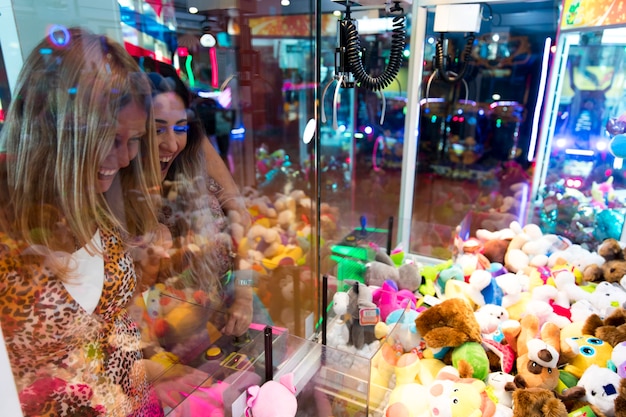 Feliz, mulheres, tocando, máquina arcade