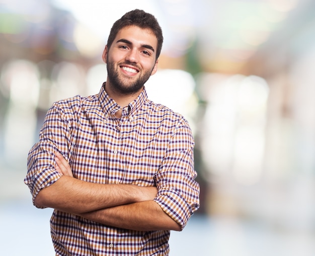 Feliz o homem posando com os braços cruzados.