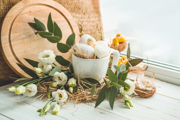 Feliz Páscoa fundo. Ovo de Páscoa em um ninho com decoração floral perto da janela. Ovos de codorna. Feliz Páscoa conceito