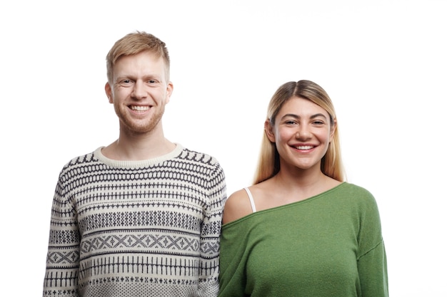 Feliz por estarmos juntos. Retrato isolado de um lindo jovem casal caucasiano, homem e mulher apaixonados, sorrindo alegremente