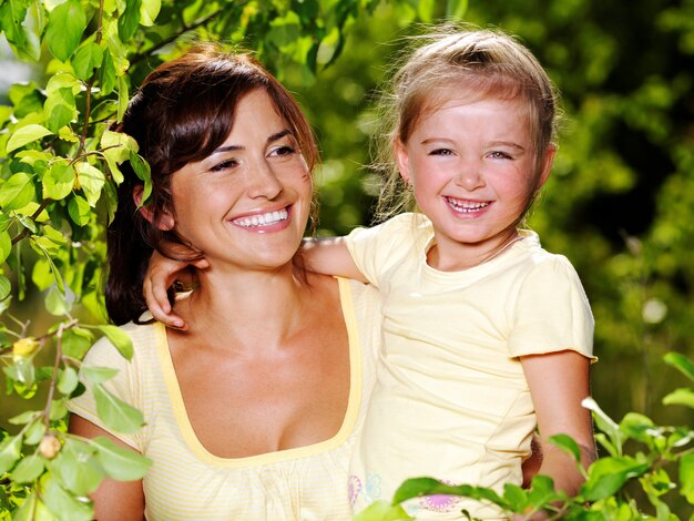 Feliz retrato da mãe e da filha ao ar livre