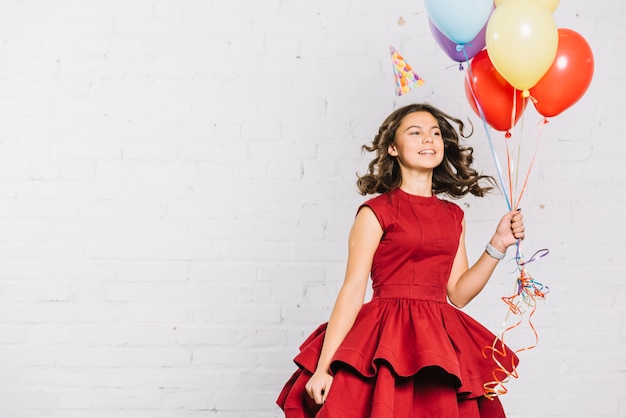 Foto grátis feliz, retrato, de, um, menina adolescente, segurando, balões, em, mão saltando