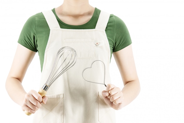 Feliz senhora segurando coisas de cozinha sobre fundo de espaço de cópia