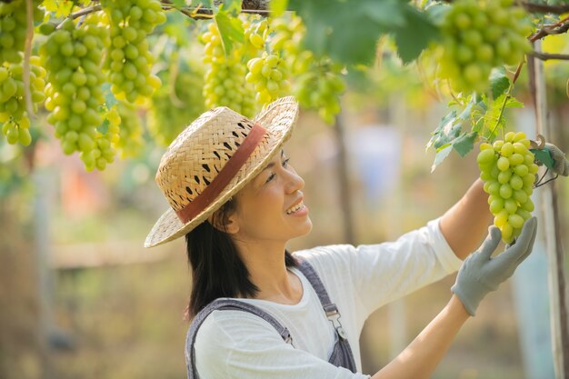 Feliz sorridente alegre vinha fêmea vestindo macacão e um chapéu de palha vestido de fazenda