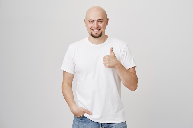 Feliz sorrindo, careca satisfeito mostrando polegar para cima