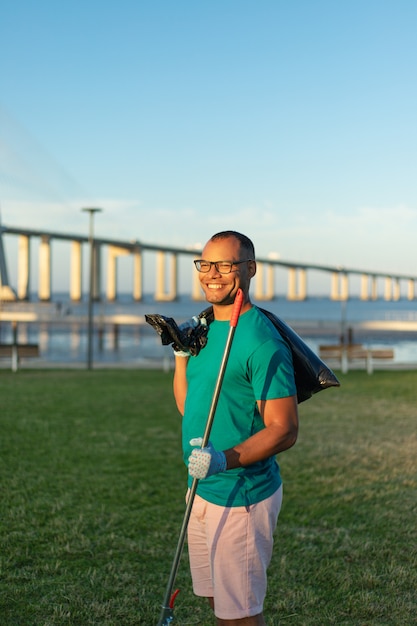 Feliz voluntário masculino posando no parque da cidade